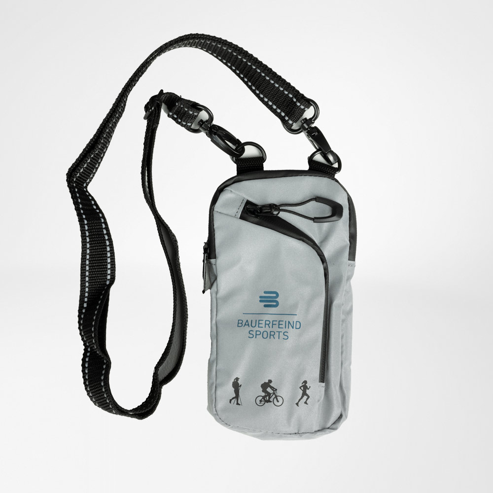 Reflective shoulder bag from Bauerfeind Sports in grey color with adjustable strap. The bag features multiple zippers and icons for hiking, cycling, and running. Ideal for outdoor activities, offering safety with reflective elements.