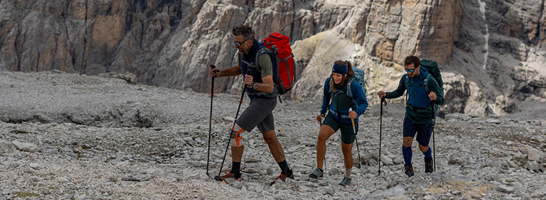 Three climbers, the first wears an outdoor knee support