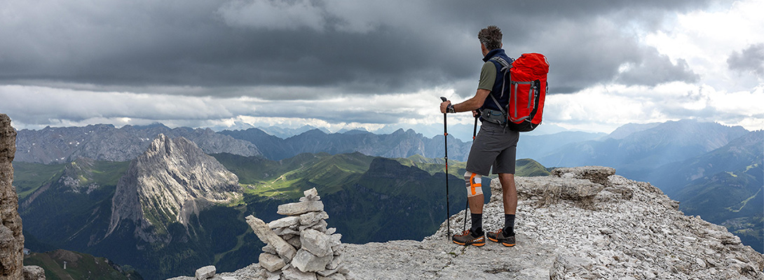 Mountaineer on a mountain peak wearing an outdoor knee support