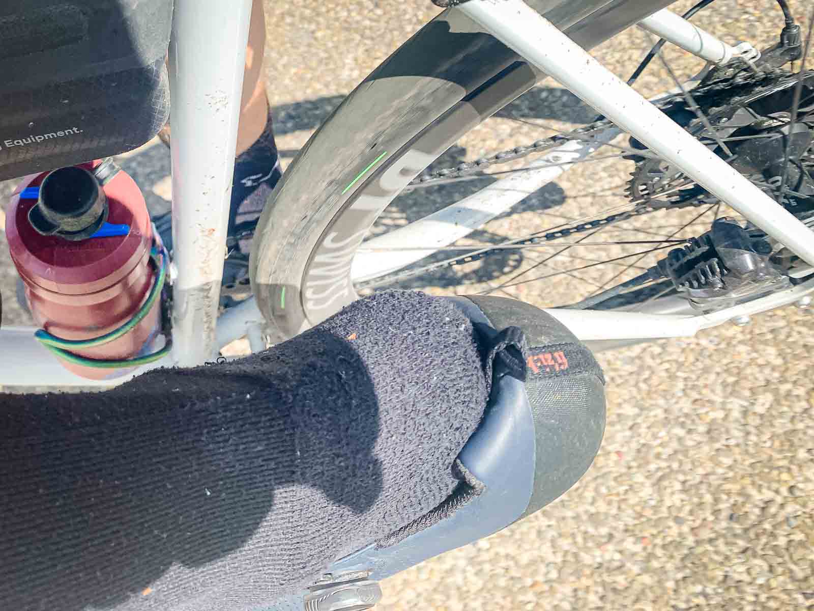 A pick protrudes from a cycling shoe while riding