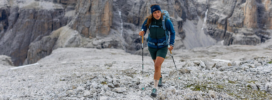 Woman hiking on rocky terrain in the Alps.