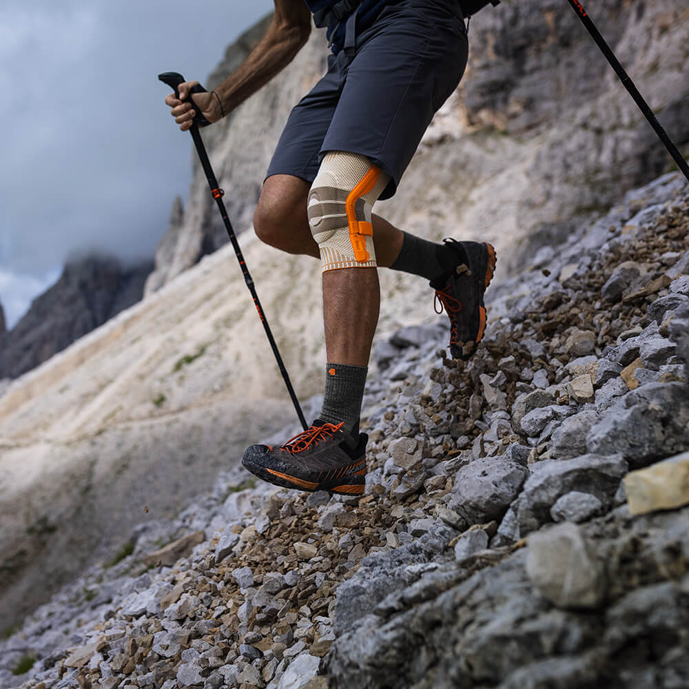 Person wearing an outdoor knee brace while hiking in the mountains