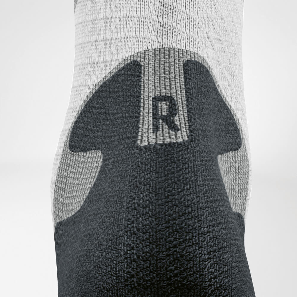 Detailed view of the Achilles' area of ​​the gray -white trail run - running socks